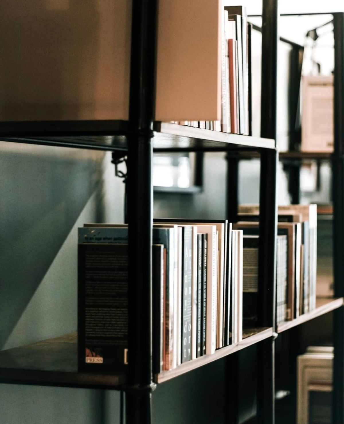 Close-up of books lined up on a dark metal shelf