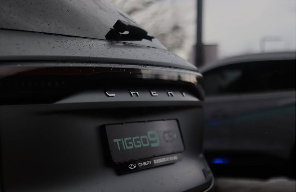 Close-up of the rear badge on a grey SUV in the rain
