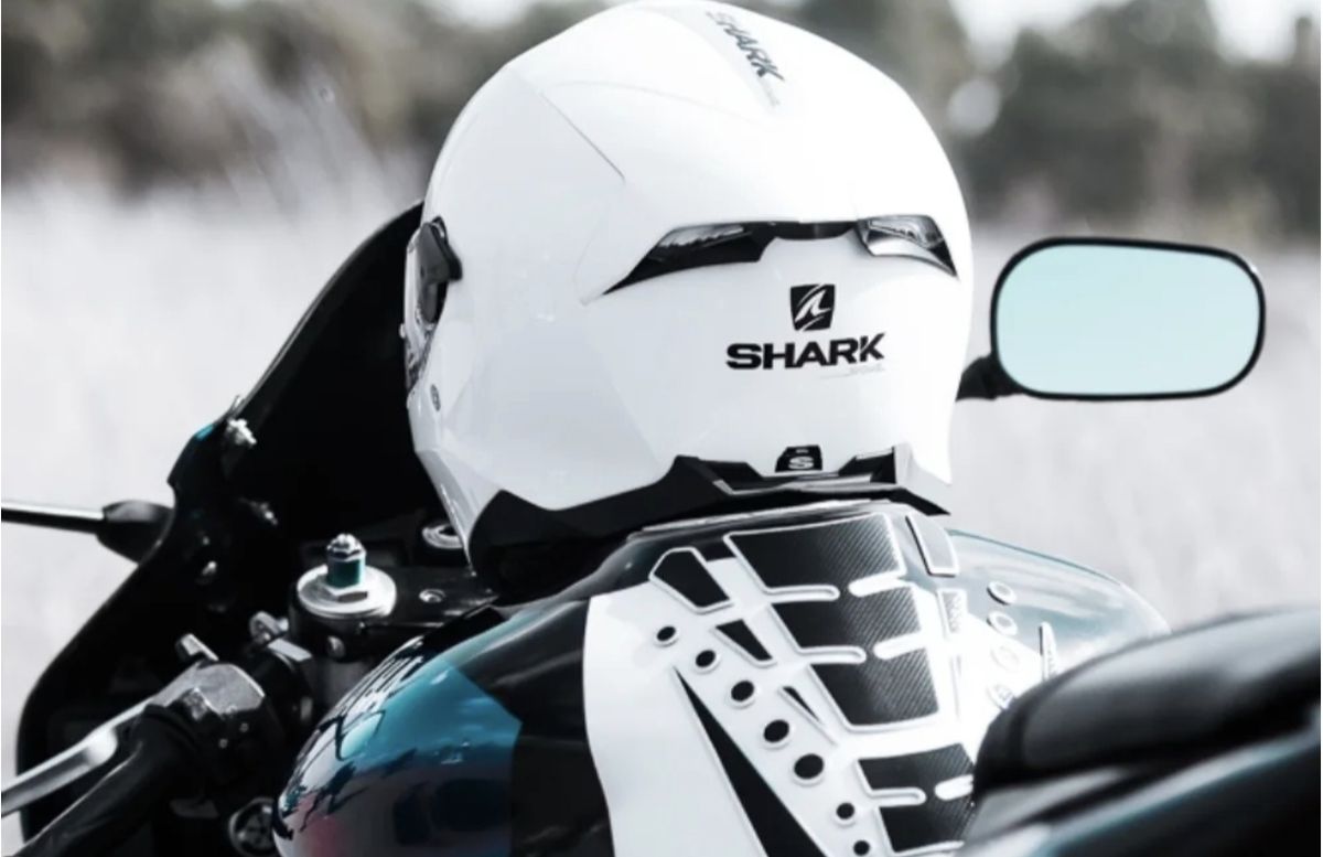 White helmet resting on the tank of a sports bike