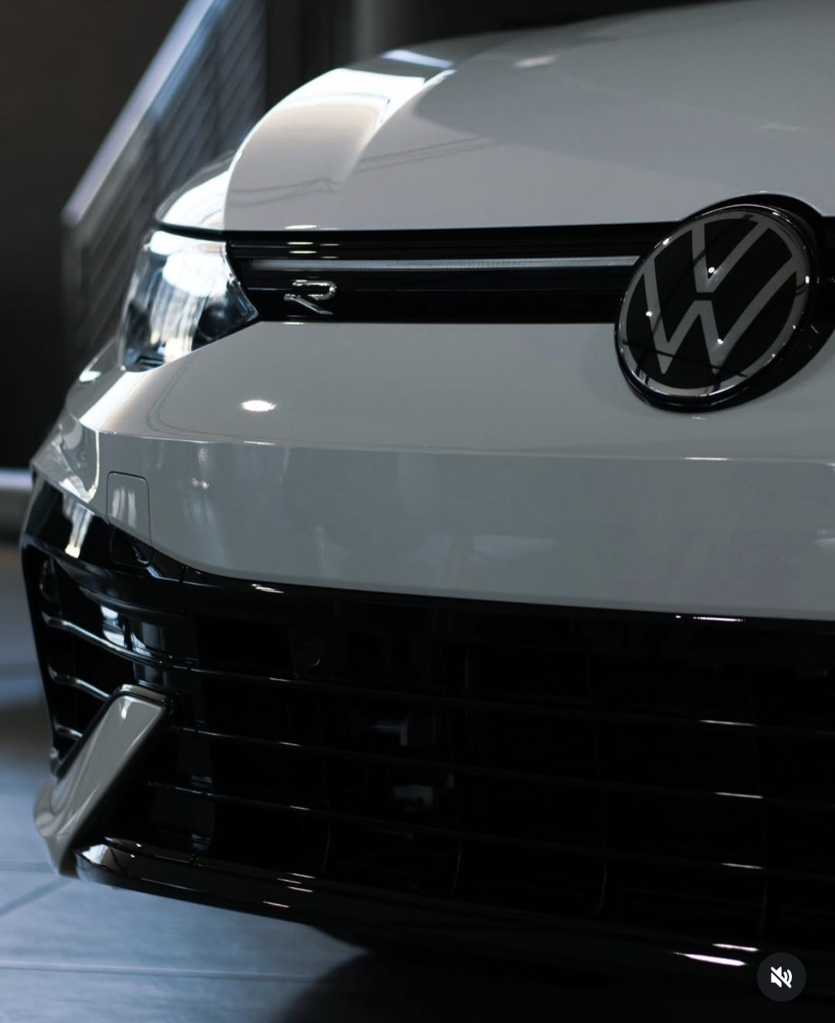 Front grille, headlight and badge of a white hatchback