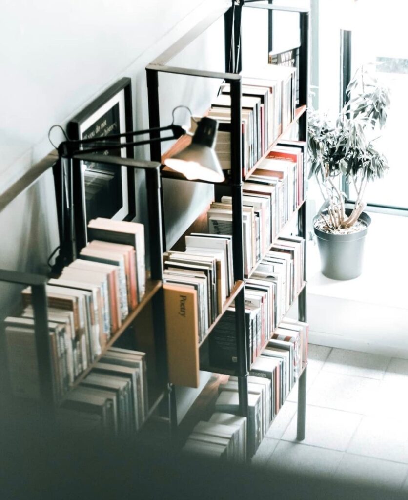 Bookshelf lit by a desk lamp
